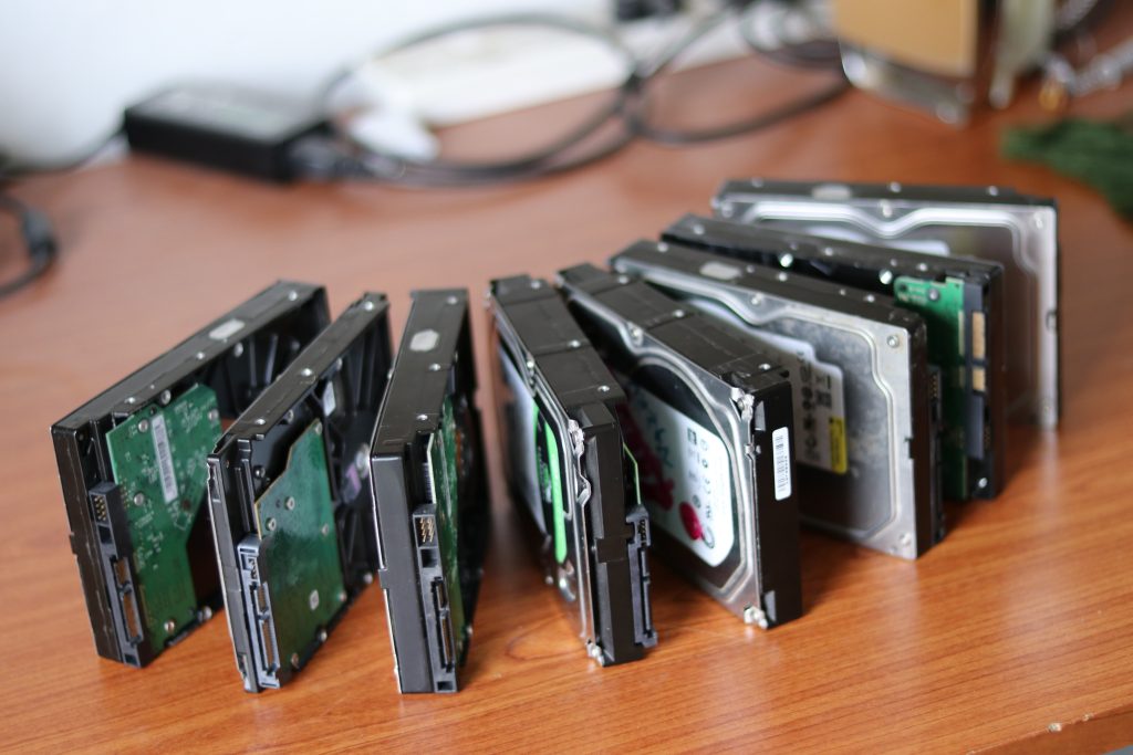 Old Computer Hard Drives On a Desk Waiting to be confidentially destroyed by shredding.